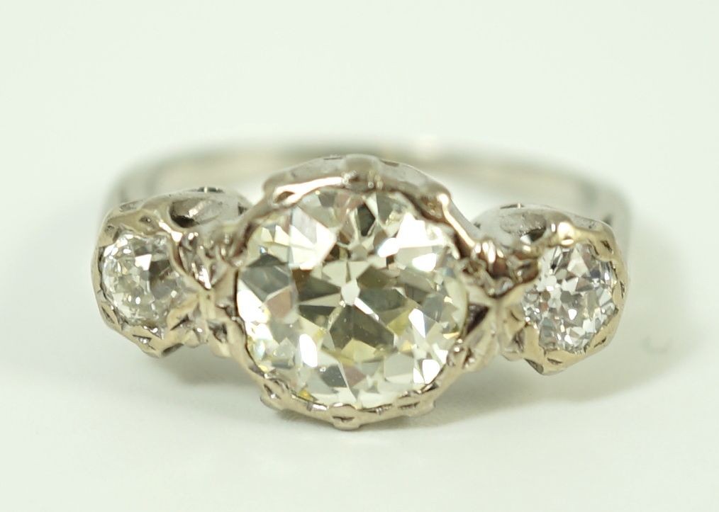 A white gold and collet set three stone diamond ring, the central stone weight approximately 2.08ct